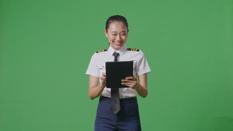 mujer piloto usando tableta en pantalla verde