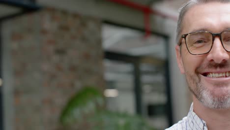 Half-face-portrait-of-caucasian-man-smiling-in-the-balcony-at-office,-copy-space