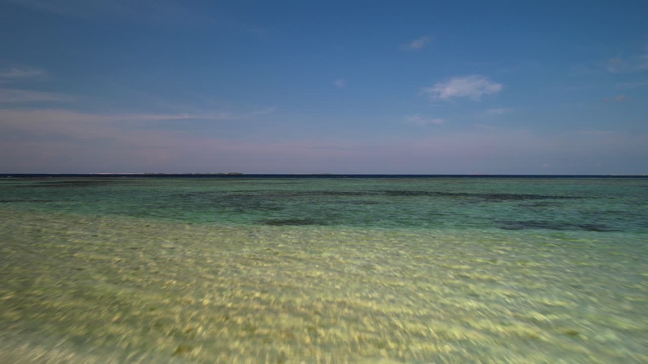 Drone shot low fly over Clear, shallow open sea water at sunset time. Tropical archipelago
