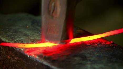 Smith-beating-hammer-on-hot-iron-on-anvil-in-forge.-Blacksmith-forging-hot-metal