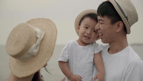 happy asian family having fun on the beach