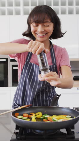 video vertical de una mujer asiática feliz preparando comida