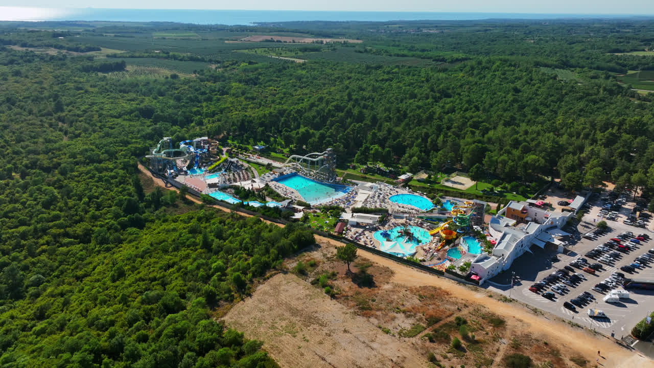 Aerial tracking shot of a large waterpark,  warm, sunny day in Southern Europe