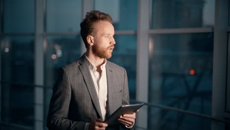 stylish young man thoughtfully flips through the pages on the tablet