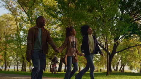 Familia-Feliz-Caminando-Por-El-Parque-De-Otoño-Tomados-De-La-Mano-Por-La-Noche.-Personas-Solidarias-Juntas.