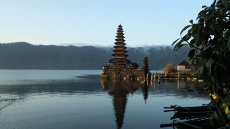 Toma-Panorámica-En-Cámara-Lenta-De-Un-Templo-Majestuoso-En-El-Agua-En-El-Lago-Volcánico-Batur-Durante-El-Viaje-De-Verano-A-Través-De-Indonesia-En-Bali-Con-Vista-De-La-Naturaleza-En-El-Fondo