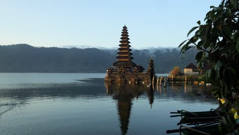 slow motion panning shot of a majestic temple in the water at volcanic lake batur during the summer trip through indonesia on bali with view of nature in the background