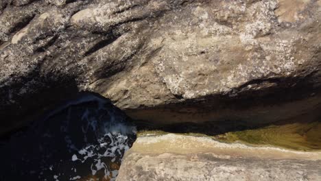 un arroyo poco profundo erosiona la piedra mientras se filtra por el caldero gigante en algorfa alicante, españa - vista aérea ascendente