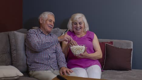 una pareja de viejos y maduros aficionados al fútbol mirando deportes en la televisión apoyan al equipo de fútbol ganador