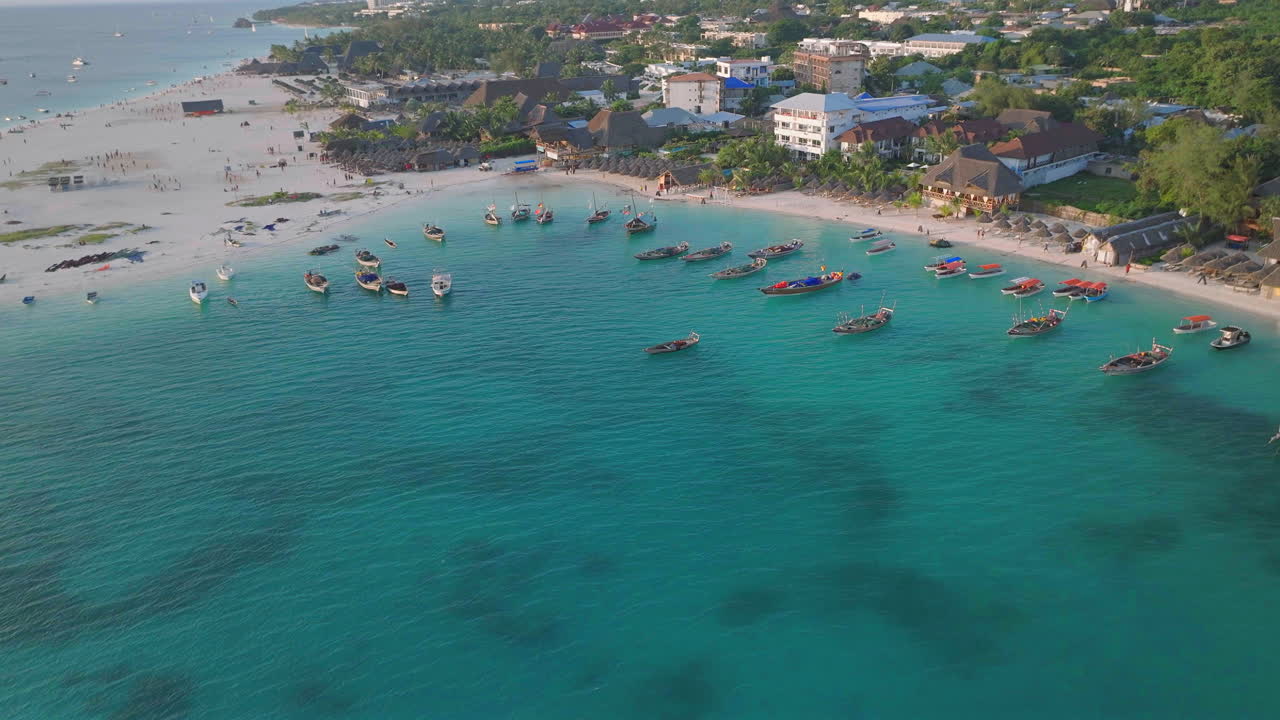 탄자니아 잔지바르 의 켄데와 마을 에서 보트 와 사람 들 을 배경 으로 한 모래 해변 의 공중 사진