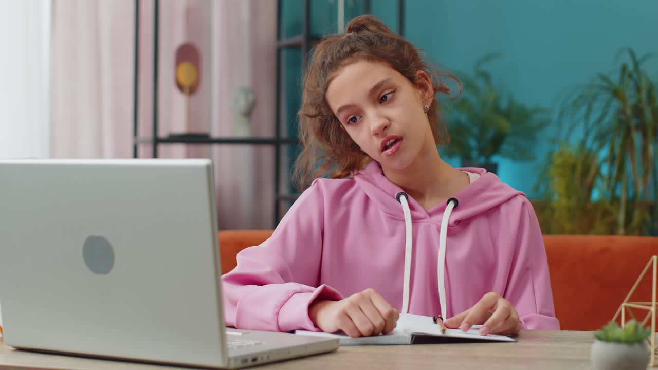 Tired preteen school girl sleeping on laptop computer with eyes stickers on face cheating to sleep