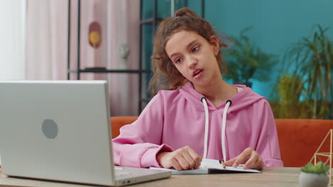 tired preteen school girl sleeping on laptop computer with eyes stickers on face cheating to sleep