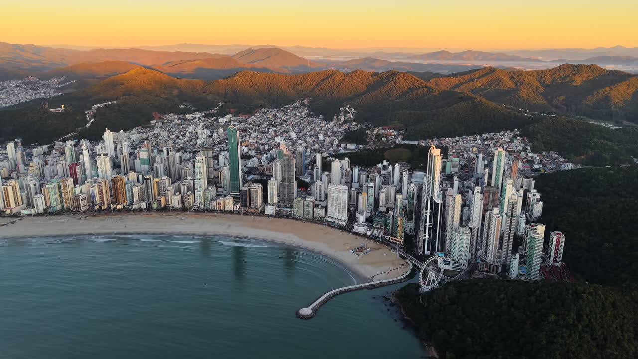 Sunset panorama aerial view of high-rise buildings and beach coastline in vibrant coastal city of Balneário Camboriú, Santa Catarina, Brazil