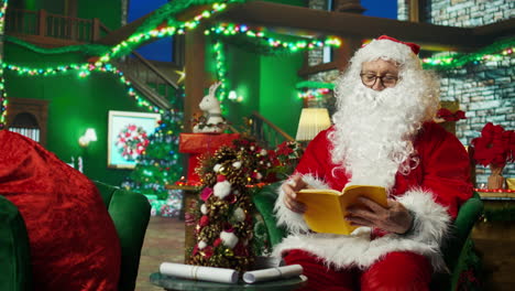 santa claus reading a book at home for christmas