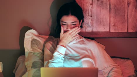 Happy-excited-woman-working-from-home-talks-on-phone-while-using-laptop