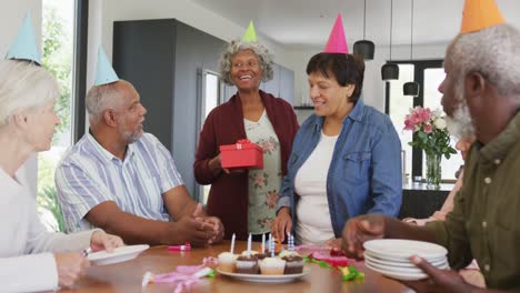 Happy-senior-diverse-people-at-birthday-party-with-cake-and-gifts-at-retirement-home