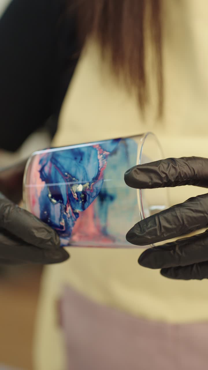 Hands holding a glass with resin art