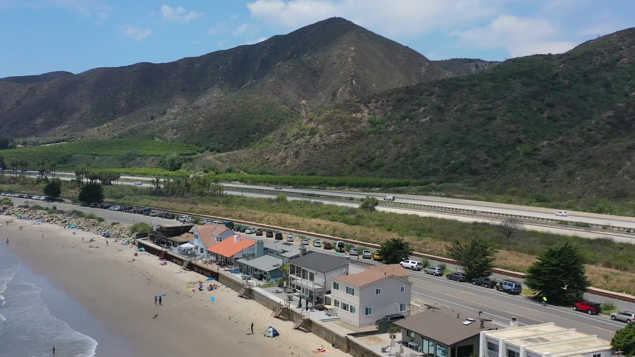 casas frente a la playa de un millón de dólares a lo largo de mondo beach en california junto a la famosa ruta uno de la autopista de la costa del pacífico con un paisaje montañoso seco y escarpado en un día soleado de verano