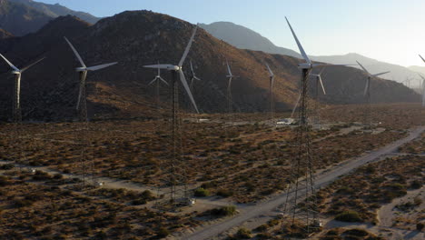 aerial view of drone spinning and revealing huge wind farm and wind turbines near palm springs in the mojave desert, california, usa