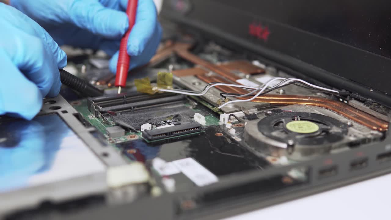 vista de primer plano de los diagnósticos de portátiles antiguos realizados por un técnico profesional con equipo especial y guantes protectores