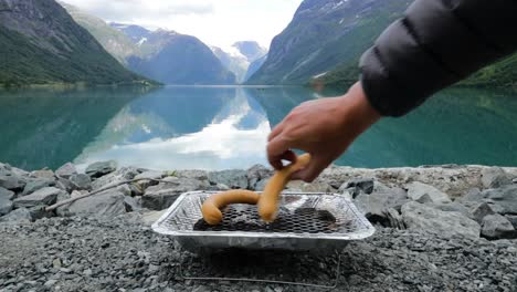 Grilling sausages on disposable barbecue grid.