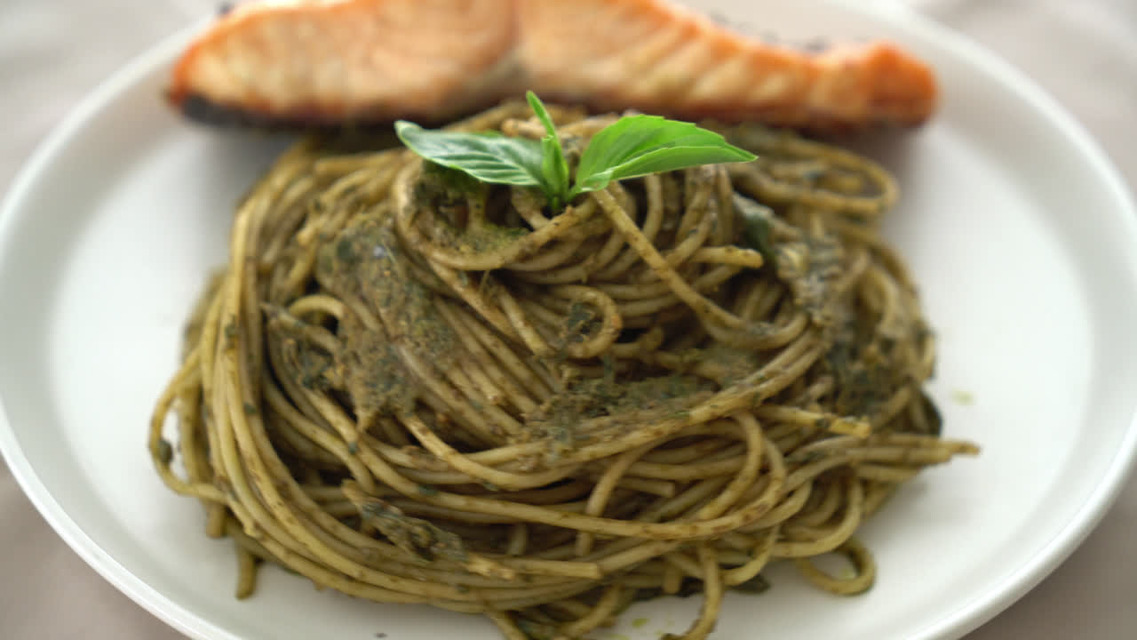 pasta de espagueti al pesto casera con salmón a la parrilla - estilo de comida italiana