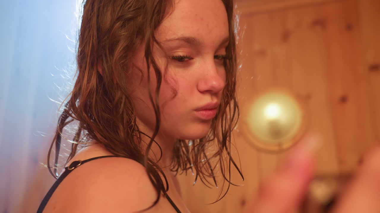 young woman in towel holds phone close makes video under warm backlight in wooden sauna with steam haze capturing relaxed moment during spa retreat in cozy ambient steam filled environment
