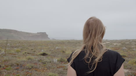 woman walking along a coastal path in foggy weather