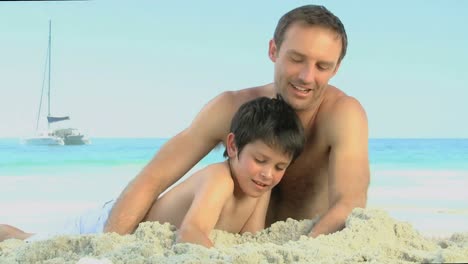 Father-helping-his-son-to-build-a-sand-castle