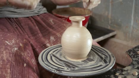 the potter makes a jug of clay. ceramist. a man makes a vase on a potter's wheel