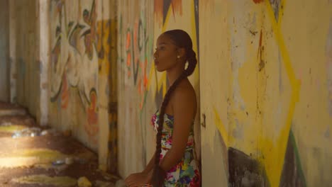 caribbean girl stands on a graffiti wall at an abandoned building in the caribbean