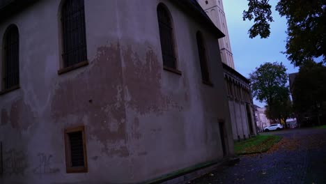 old-horror-house-with-white-chipped-plaster-in-the-evening-and-large-black-windows