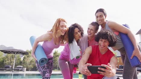 Fröhliche-Gruppe-Verschiedener-Freunde,-Die-Yogamatten-In-Der-Hand-Halten-Und-Ein-Selfie-Machen