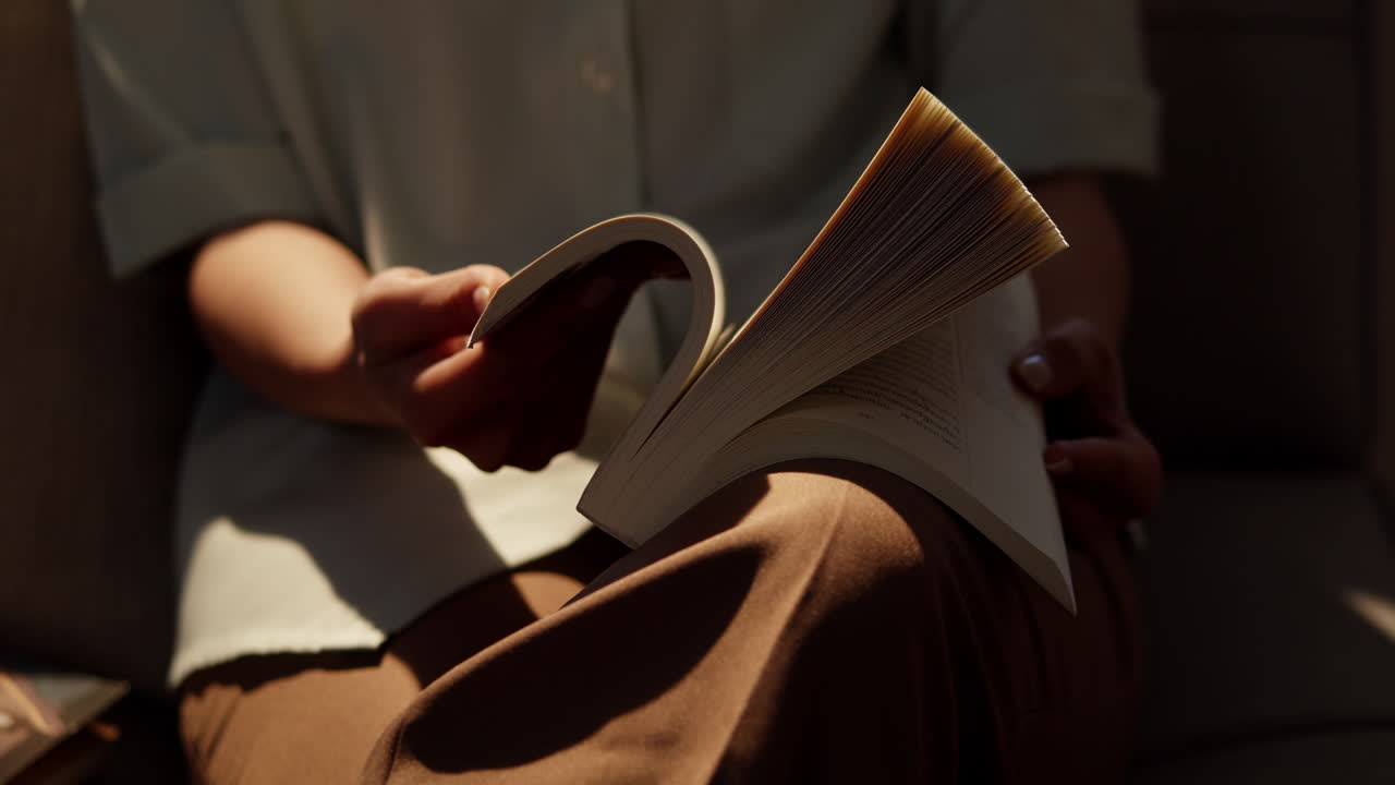 An individual perusing a resource book in the library.