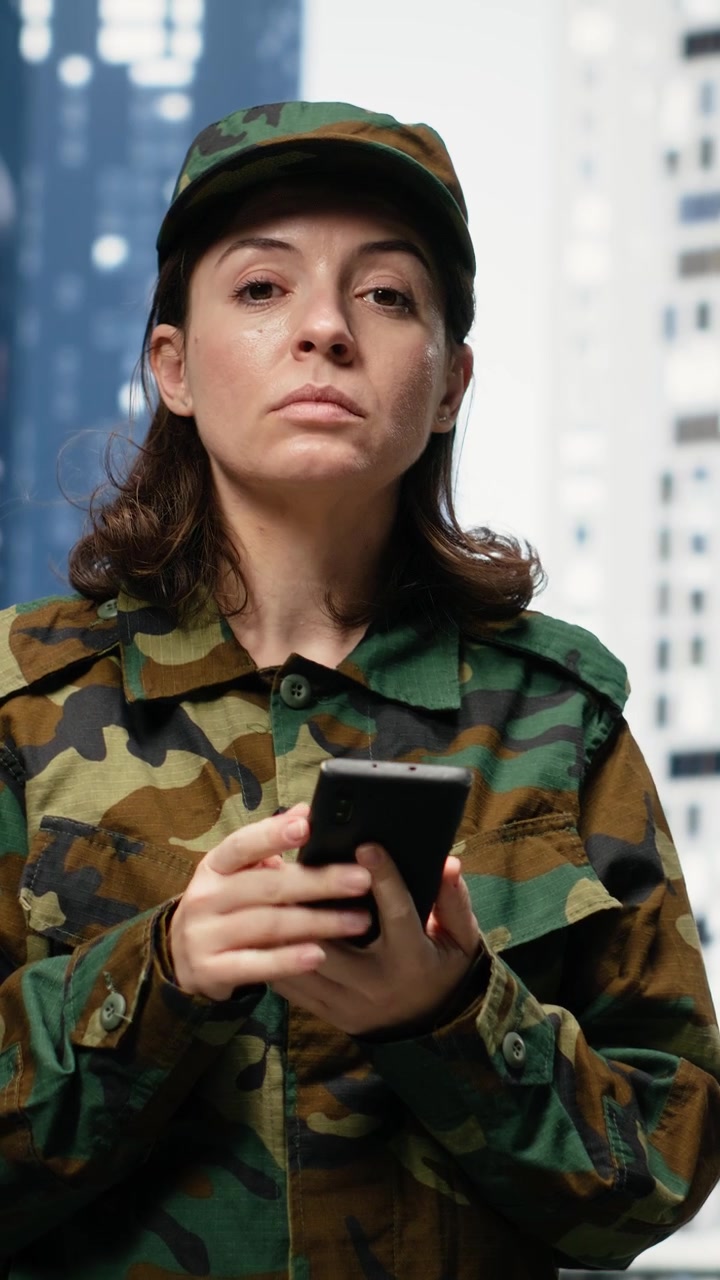 Video verticale: Soldatessa allegra usa lo smartphone per strada in città all'aperto
