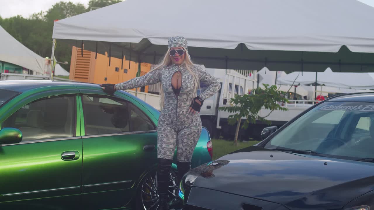 On a sunny day in a tropical island setting, a girl finds joy at a car show.