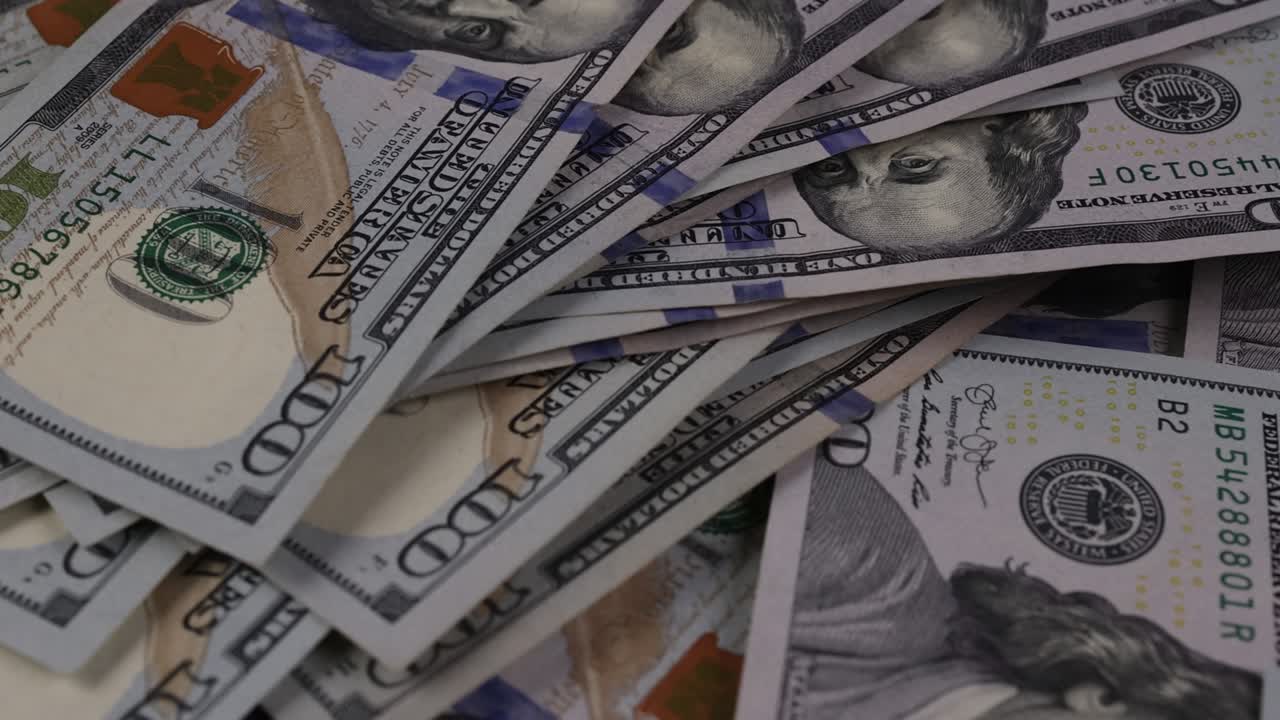 Billetes de dólar americano con dinero en efectivo esparcidos sobre la mesa