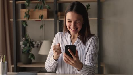 joven lee el mensaje en el teléfono inteligente celebra grandes noticias