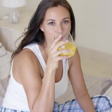 smiling healthy young woman drinking orange juice