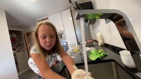 girl washing her hands full of flour after playing cooking