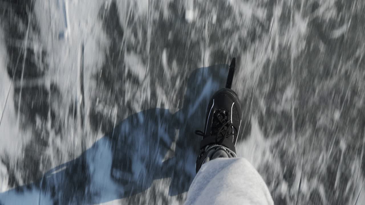 얼어붙은 얼음 호수에서 스케이트를 타고 미끄러지는 남자. 검은 스케이트에 은 남성의 다리는 겨울에 얼어붙는 강에서 야외에서 스케이팅하고 있습니다. 겨울 스포츠 활동. 남성의 발은 얼음 위에 스케이트 타고 있습니다.