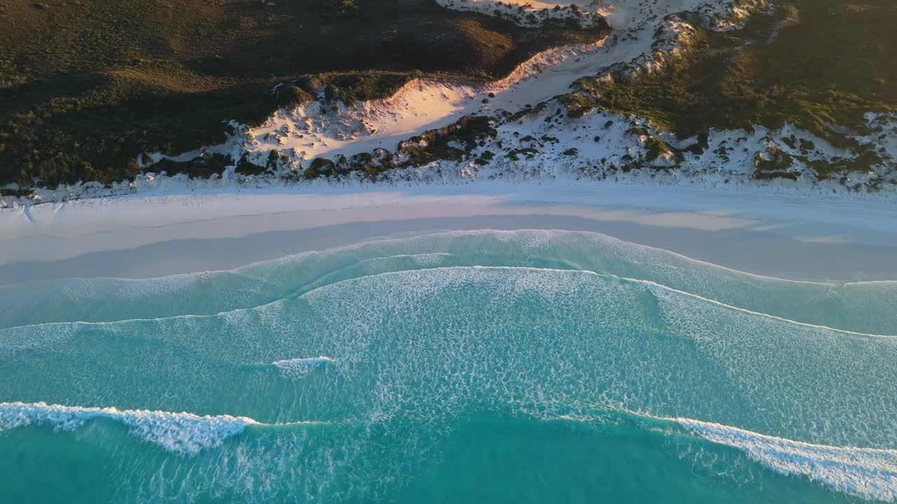 Waves on white sand beach at sunrise