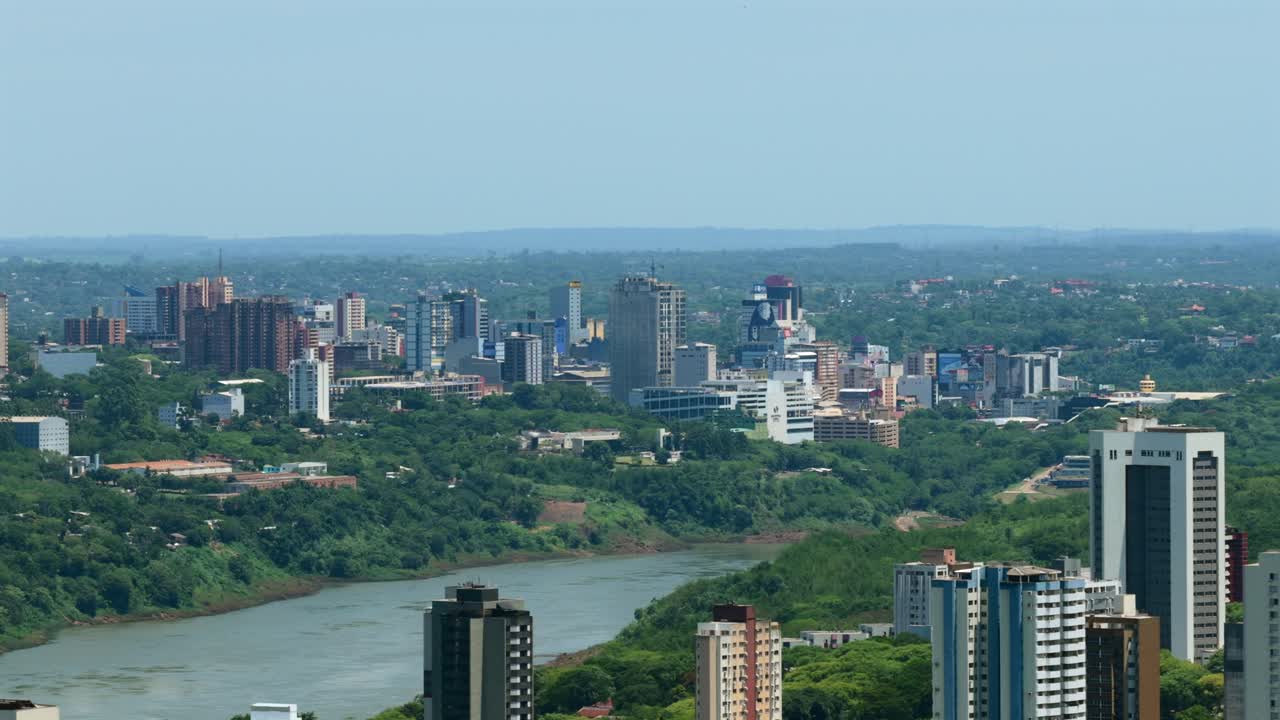 Ripresa aerea orizzontale con drone dello skyline di Foz do Iguaçu verso Ciudad del Este oltre il fiume