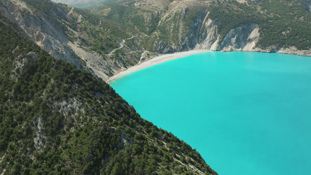 Stunning views of Myrtos Beach surrounded by rocky mountains and turquoise colored water, Greece