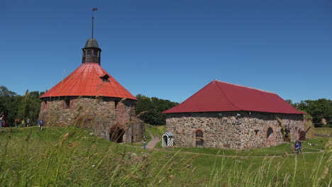 a front view of the museum fortress korela with blue sky and green shrubs, russia