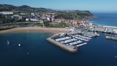 Drone-tilt-view:-Beach-and-marina-of-Spanish-fishing-village-on-coast