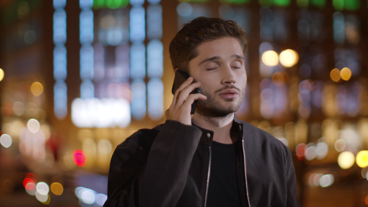 길거리에서  ⁇ 드폰으로 얘기하는 피곤한 남자.  ⁇ 드폰으로 서 있는 짜증나는 남자.