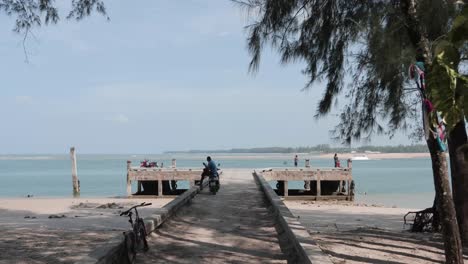 Tropical Beach in Thailand with Palm Trees, dock and man on moped 4K Footage