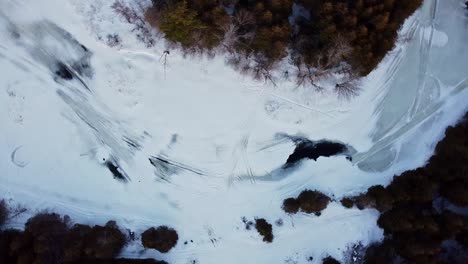 Rotating-vertical-drone-shot-of-a-frozen-river-in-Canada