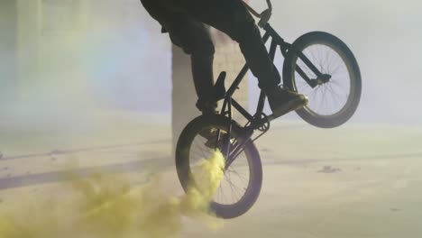 bmx rider in an empty warehouse using smoke grenade